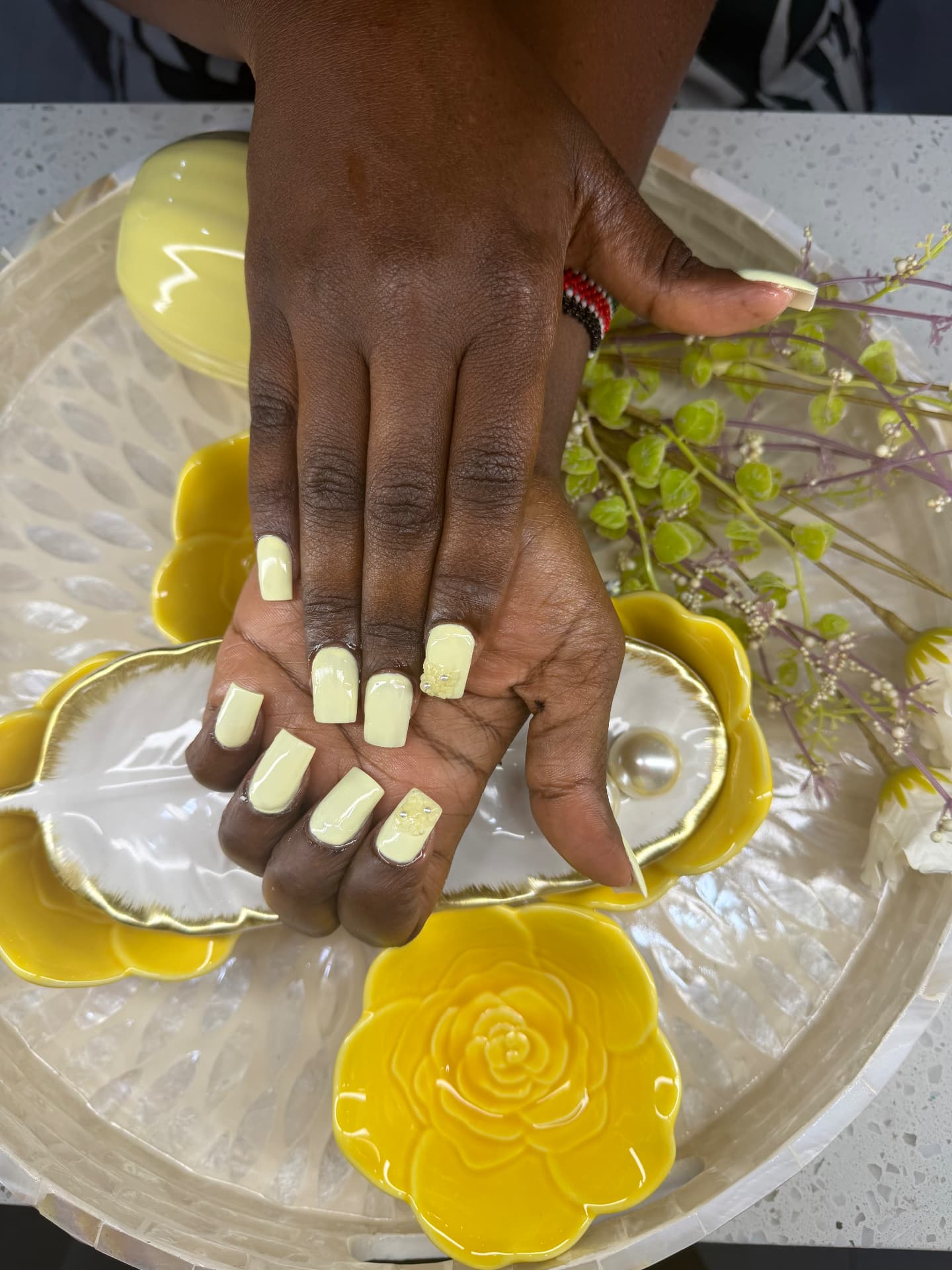 Pastel yellow manicure with floral nail art